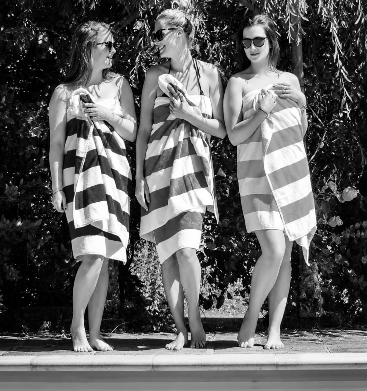 Three people holding regular towels with their hands occupied